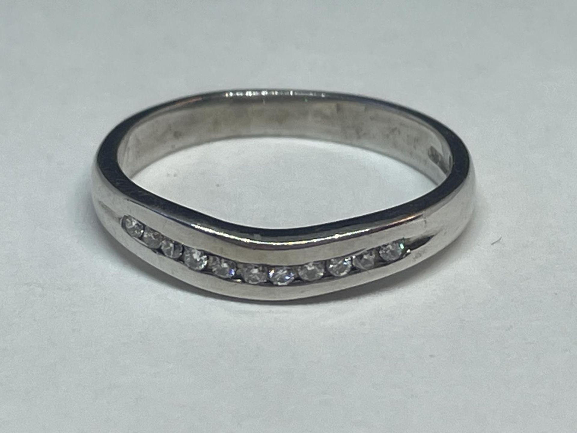 A 9 CARAT WHITE GOLD RING WITH A LINE OF DIAMONDS IN A WISHBONE DESIGN SIZE K