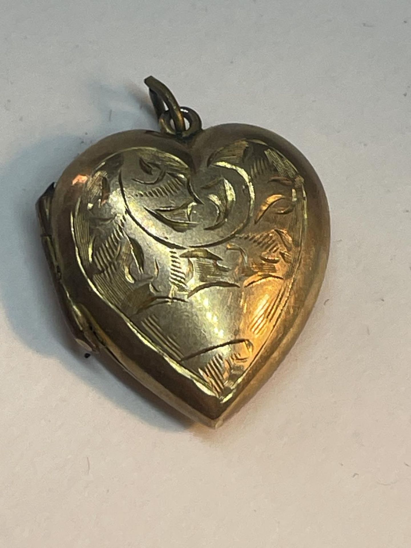 A 9 CARAT GOLD HEART LOCKET WITH VINTAGE PHOTOGRAPHS GROSS WEIGHT 3.28 GRAMS