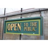 A HAND PAINTED 'OPEN TO THE PUBLIC' WOODEN SIGN