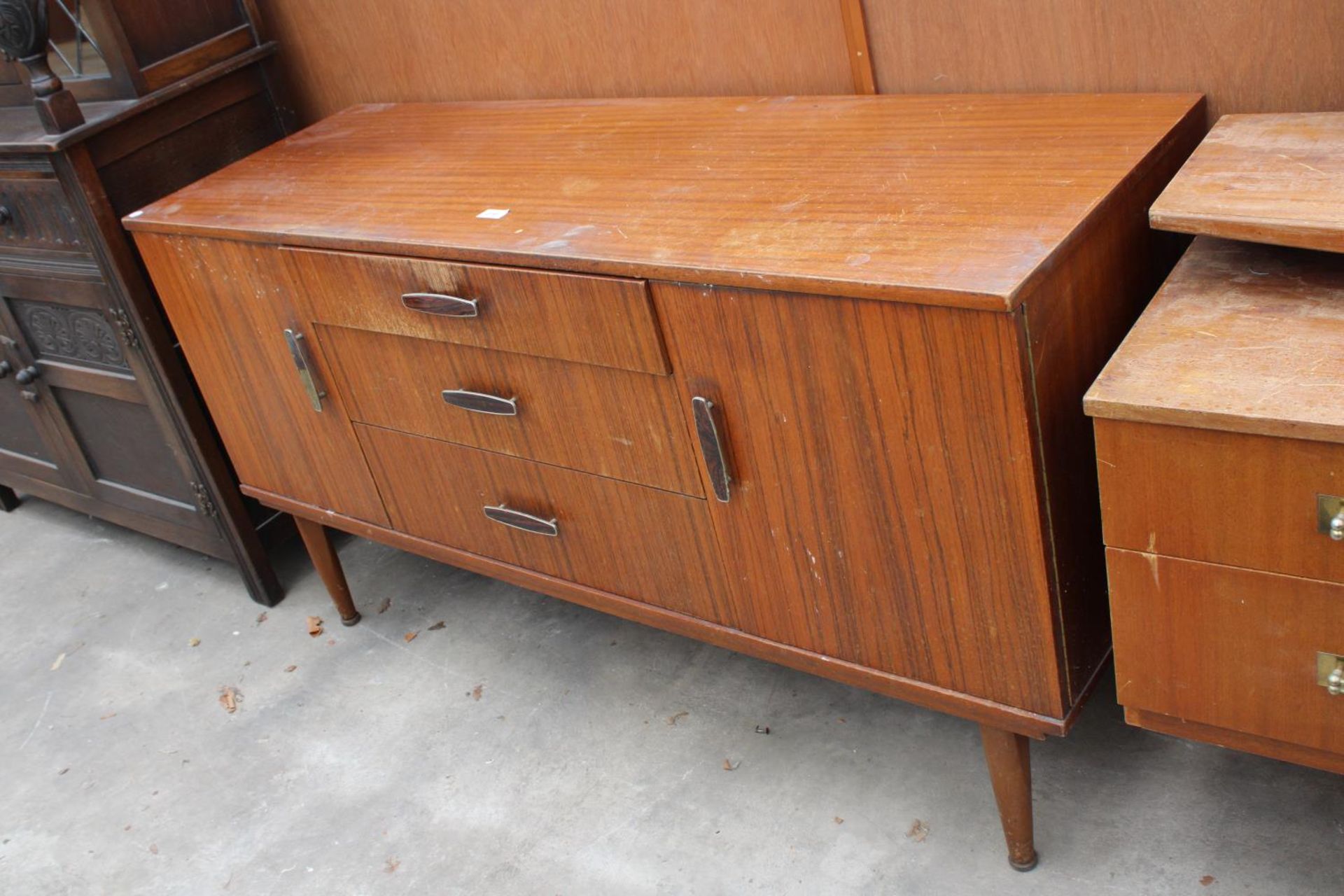 A RETRO TEAK SIDEBOARD ENCLOSING THREE DRAWERS AND TWO CUPBOARDS, 54" WIDE