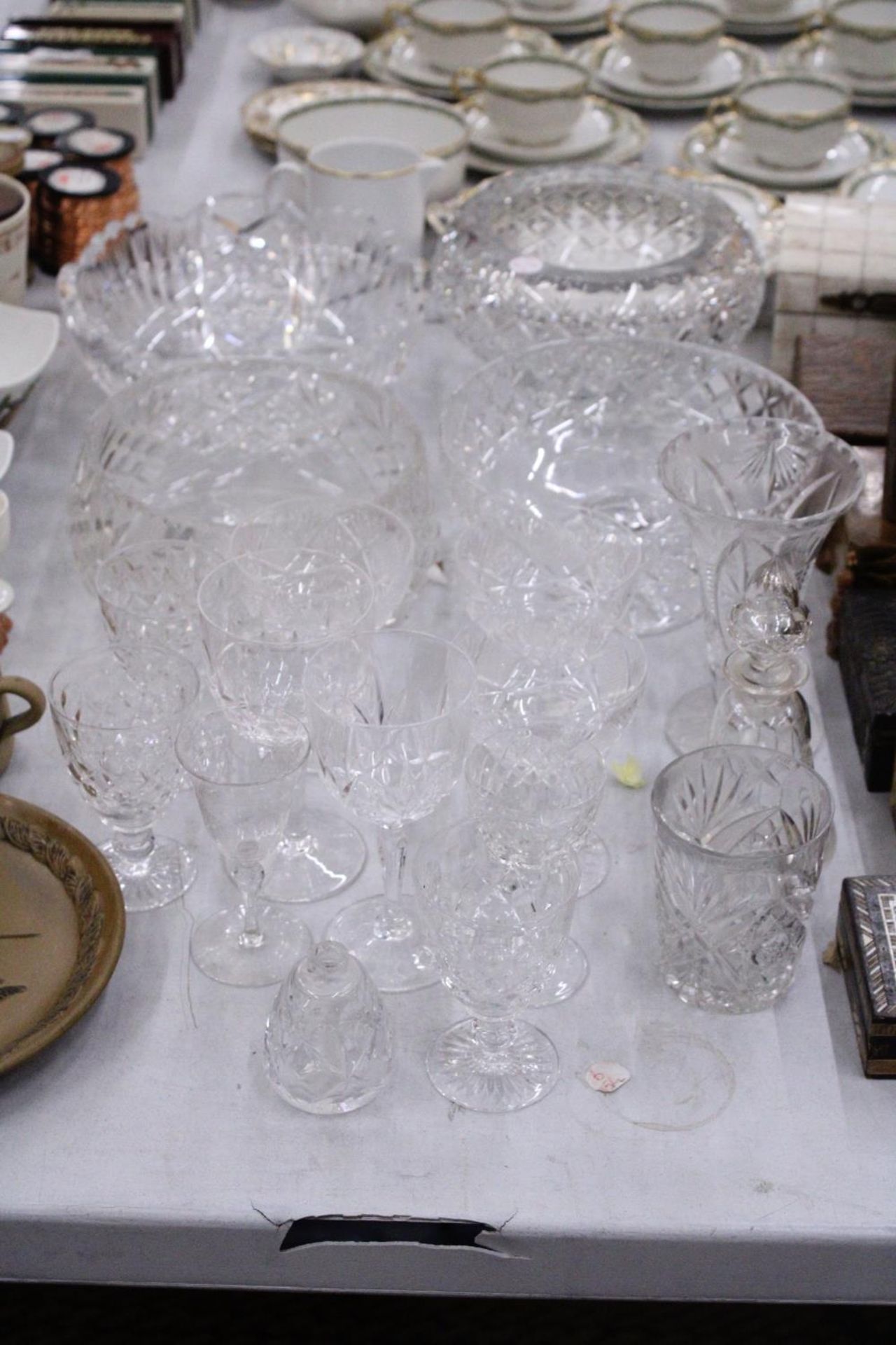 A LARGE QUANTITY OF GLASSWARE TO INCLUDE BOWLS, VASES, WINE GLASSES, ETC