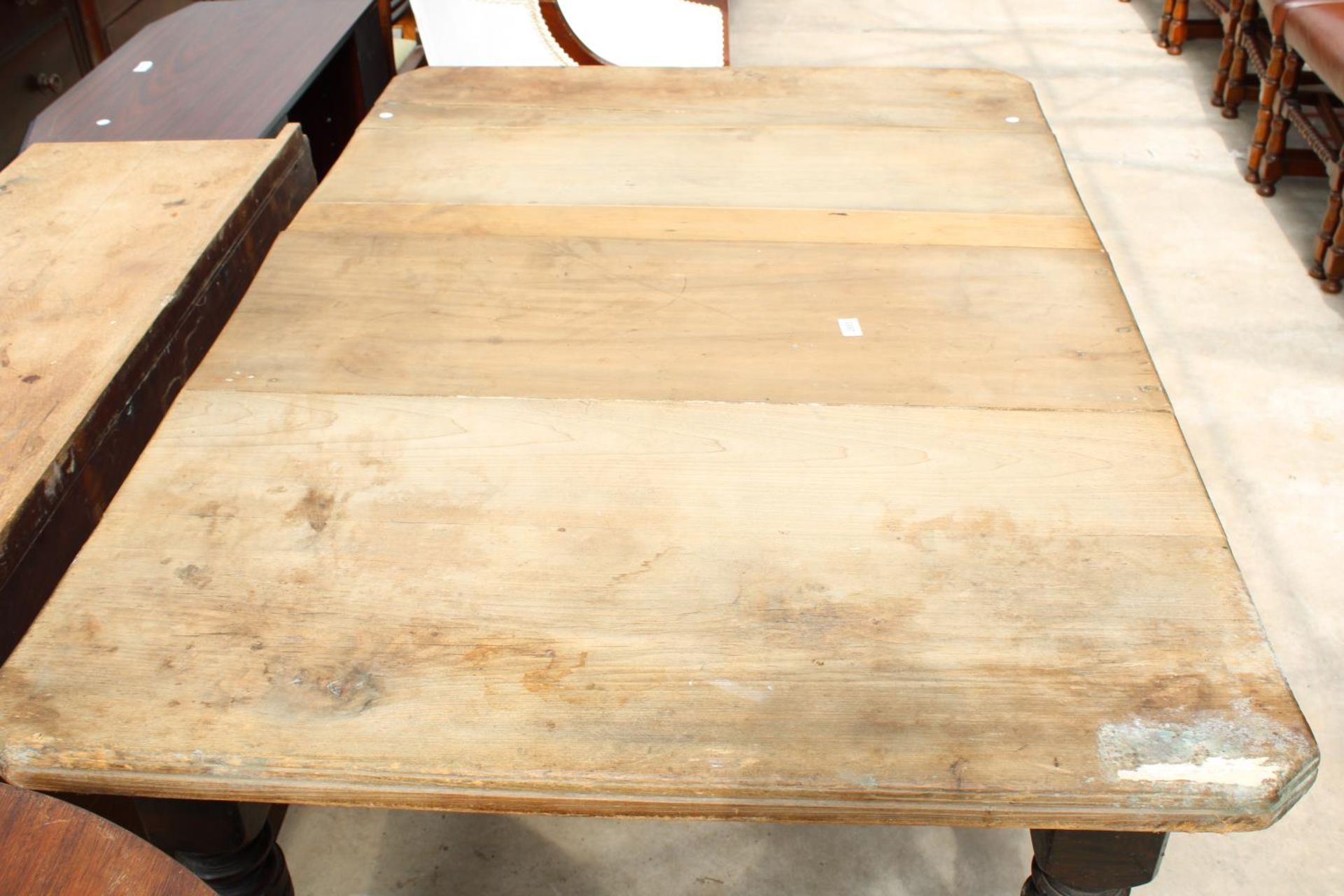 A LATE VICTORIAN SCRUB TOP WIND-OUT DINING TABLE WITH CANTED CORNERS ON TURNED AND FLUTED LEGS - Bild 3 aus 3