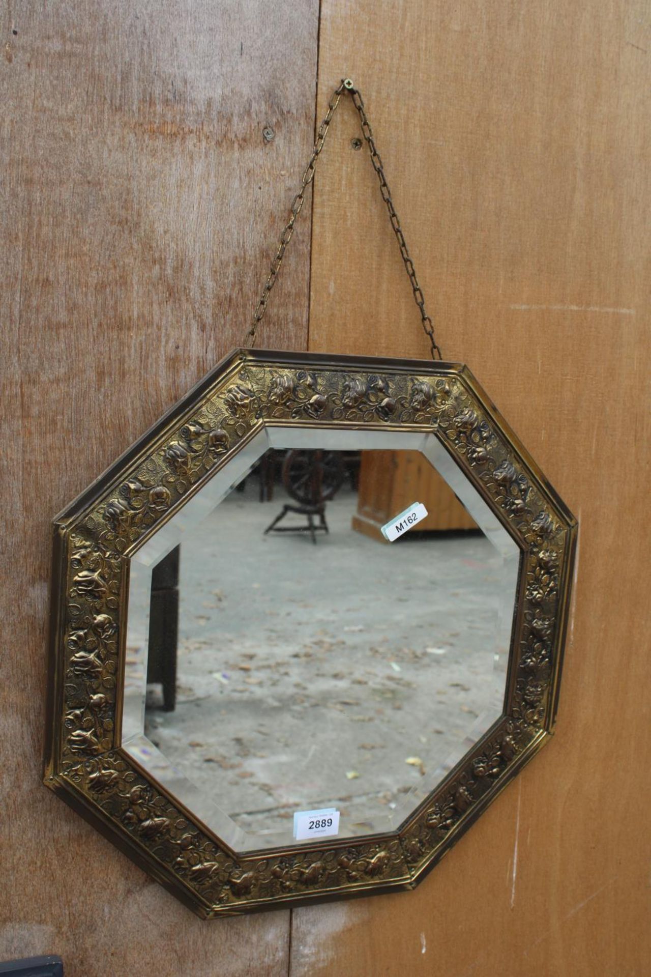 AN OCTAGONAL EMBOSSED BRASS BEVEL EDGE WALL MIRROR