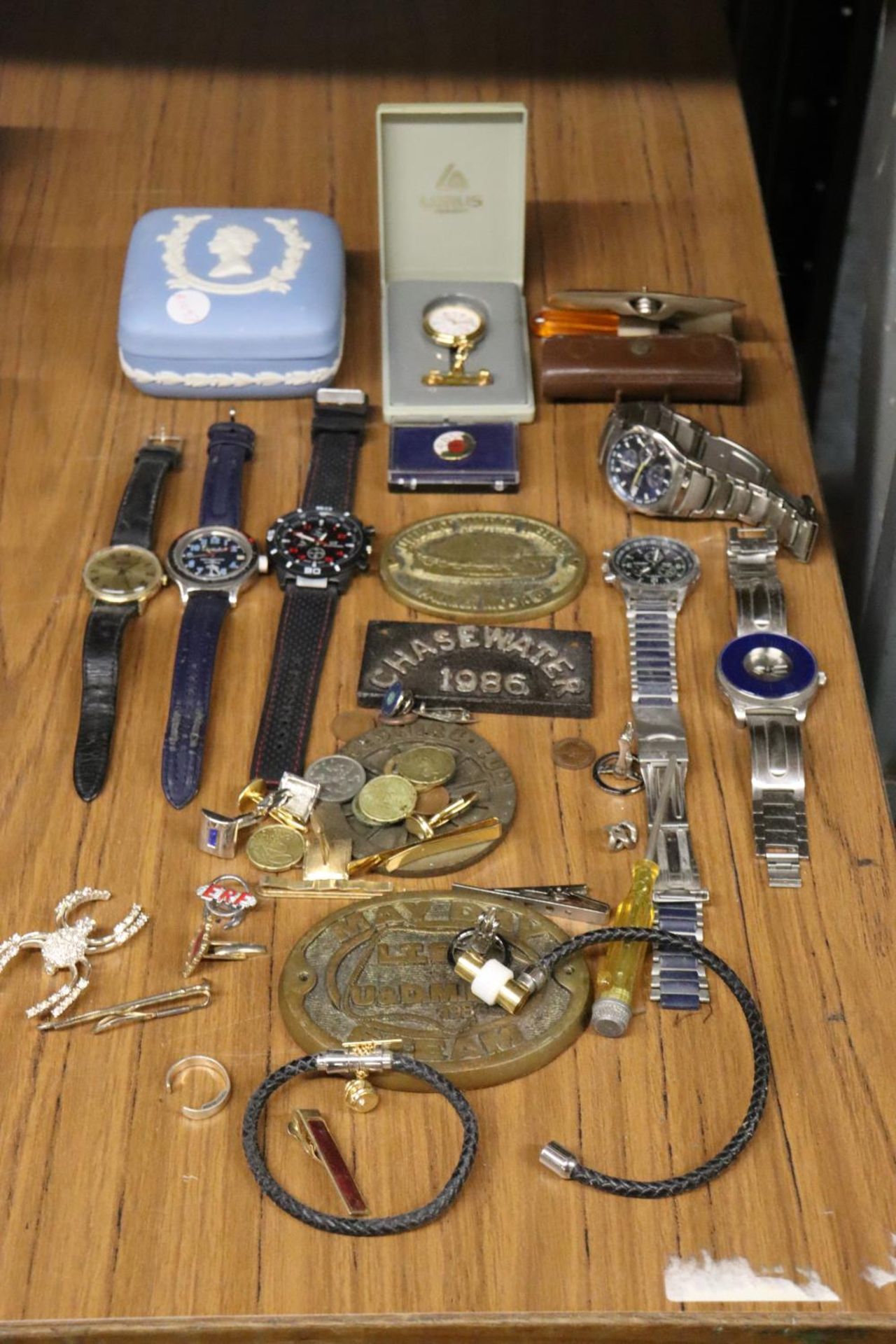 A MIXED LOT TO INCLUDE WRISTWATCHES, A POCKET WATCH, BRACELETS, TIE CLIPS, BRASS PLAQUES, A WEDGWOOD