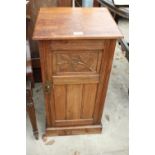 A LATE VICTORIAN MAHOGANY POT CUPBOARD WITH CARVED PANEL DOOR