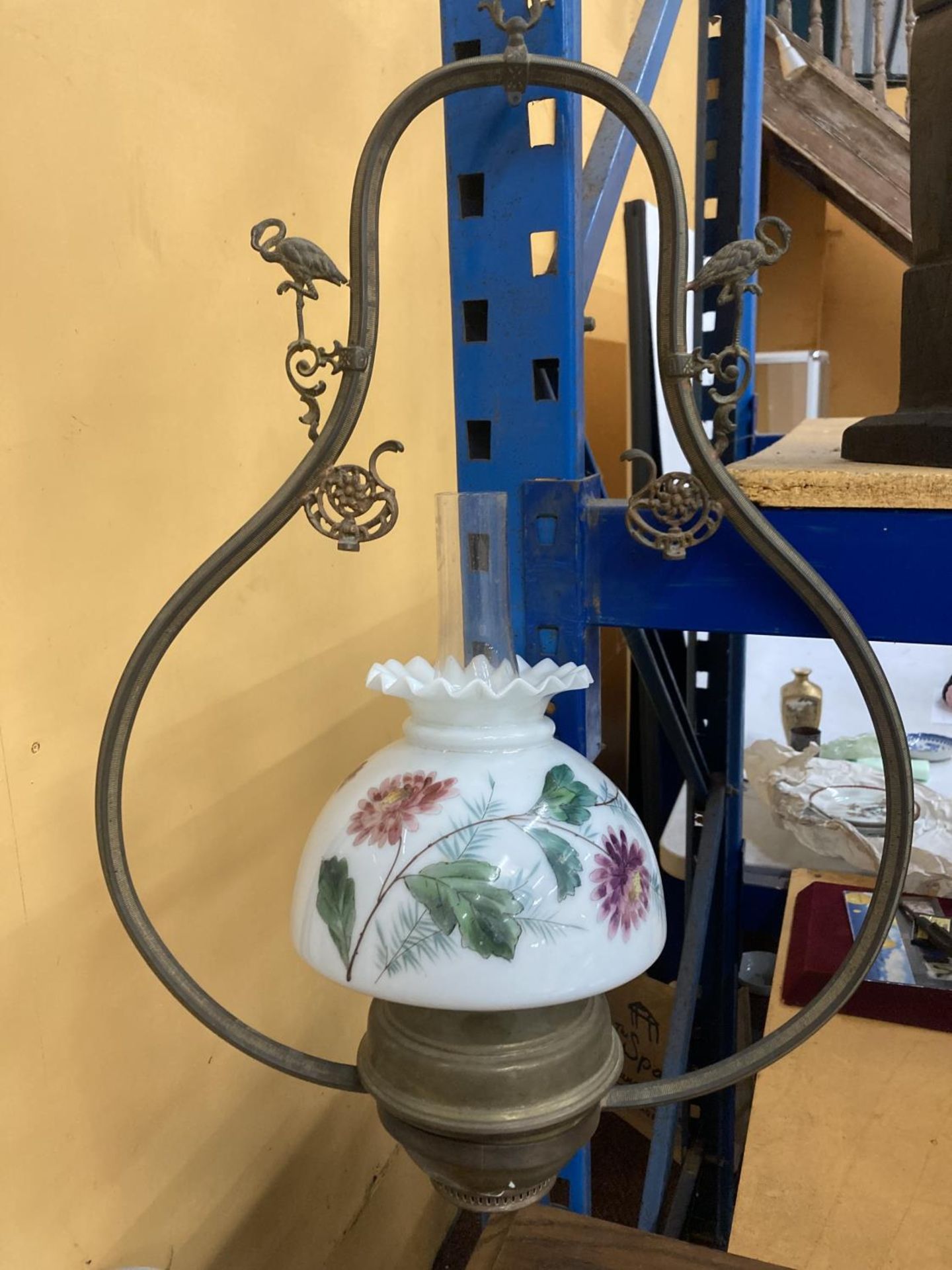 A VINTAGE HANGING OIL LAMP WITH PAINTED GLASS SHADE AND FLAMINGO DECORATION