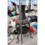 A CAST METAL GARDEN CHIMENEA WITH A COVER
