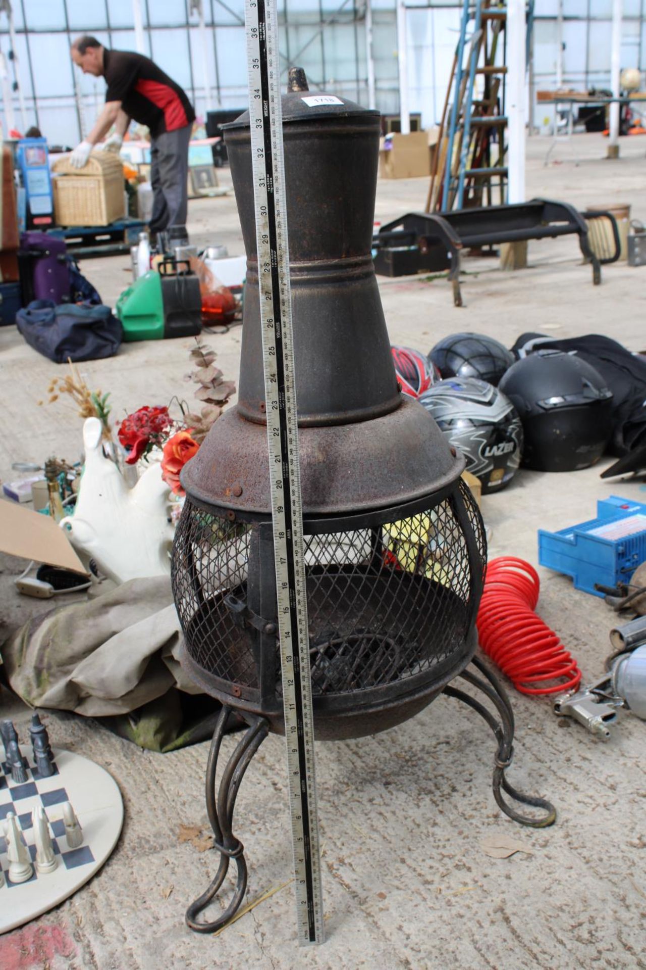 A CAST METAL GARDEN CHIMENEA WITH A COVER