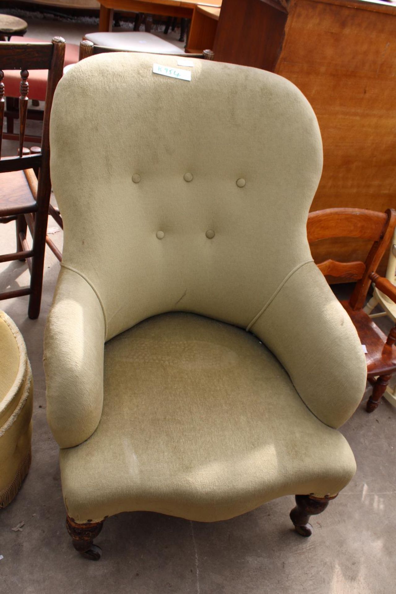 A VICTORIAN SPRUNG AND UPHOLSTERED LOUNGE CHAIR WITH BUTTON-BACK AND TURNED FRONT LEGS