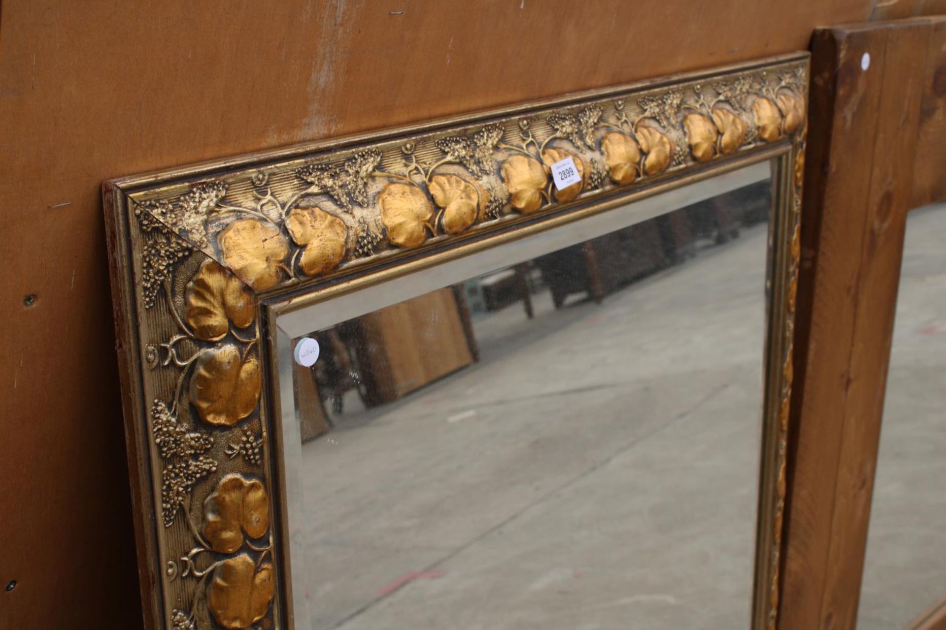 A MODERN GILT FRAMED WALL MIRROR WITH BEVEL EDGE AND FOLIATE DECORATION, 48" X 37" - Image 2 of 3