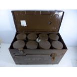 A GREEN PAINTED METAL CASE CONTAINING EIGHT FIRED 25 POUNDER BLANK LIAI SHELL CASES. THESE ARE THE