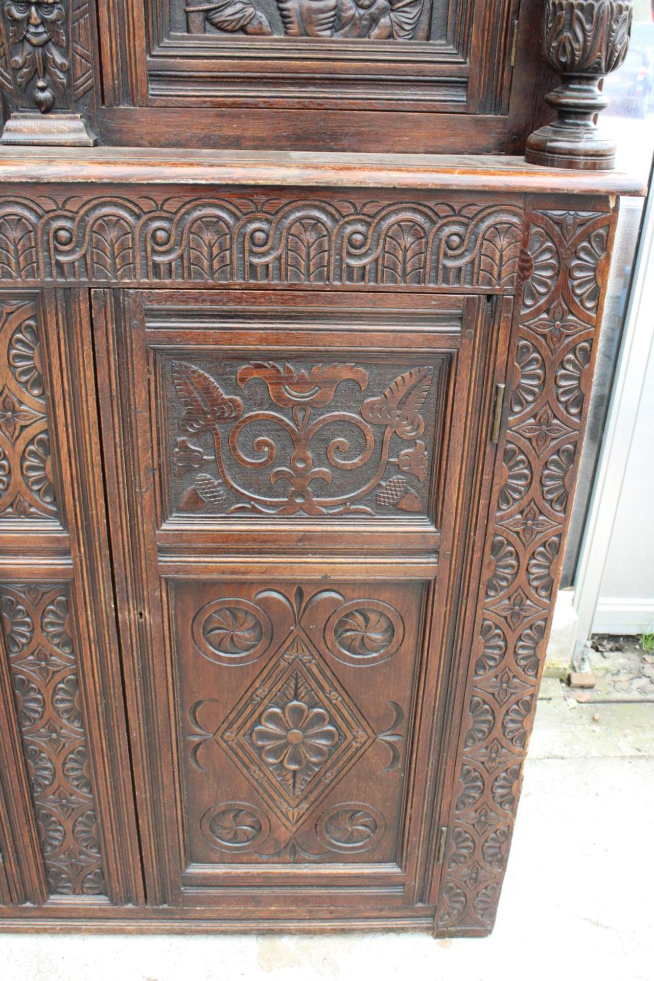 AN OAK GEORGE III STYLE COURT CUPBOARD WITH CARVED PANELS, THREE DEPICTING THE BIRTH AND - Image 7 of 13