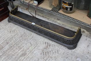 A VINATGE AND HEAVILY ORNATE CAST IRON FIRE FENDER WITH BRASS TRIM