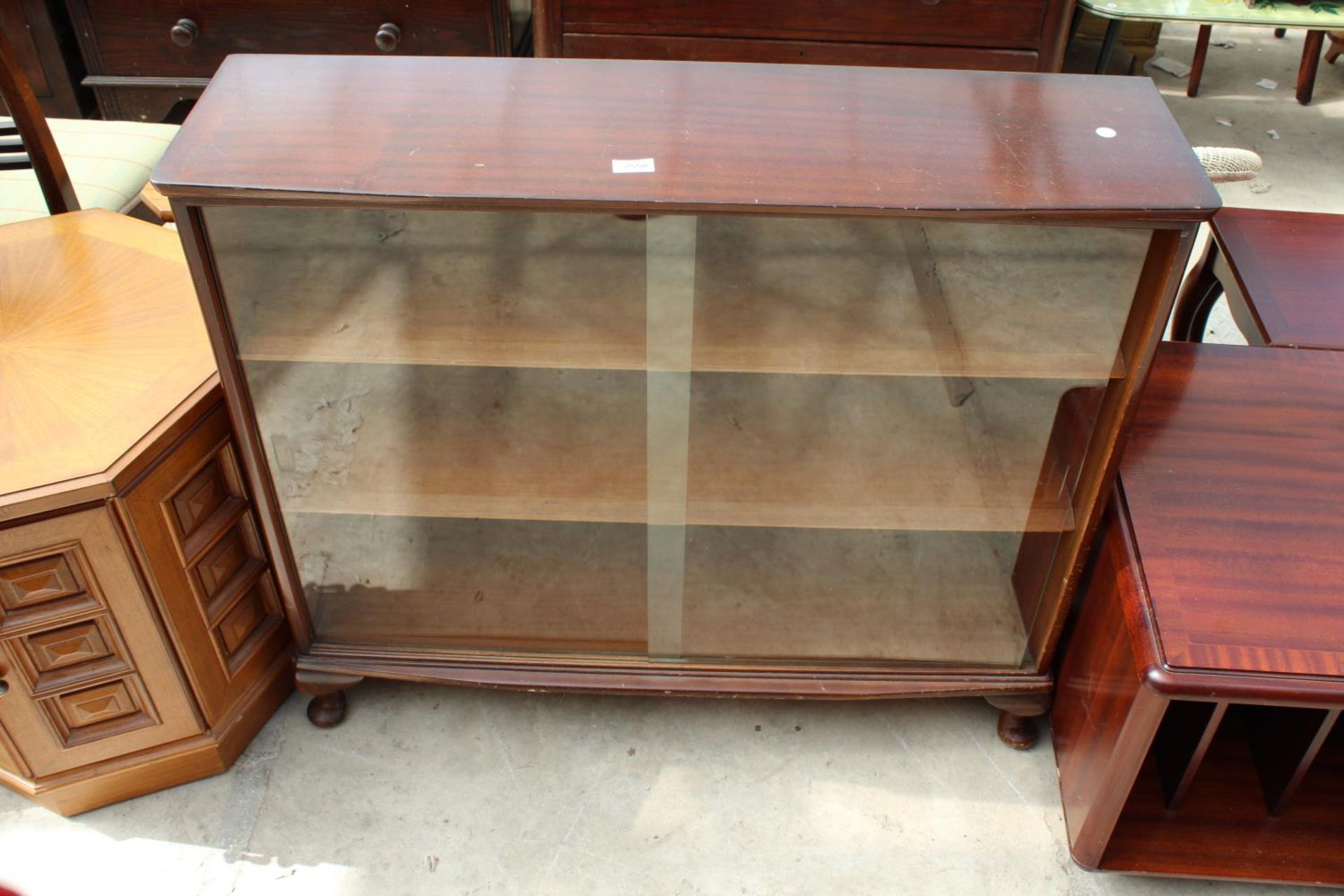A MID 20TH CENTURY MAHOGANY BOOKCASE WITH 2 GLASS SLIDING DOORS ON CABRIOLE LEGS, 39" WIDE