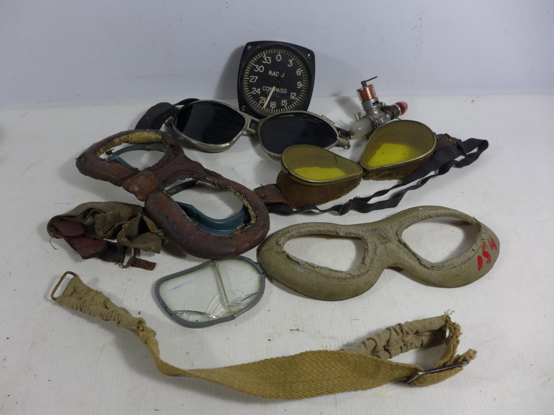 A COLLECTION OF FLYING GOGGLES, RADIO COMPASS DIAL, MODEL ENGINE ETC