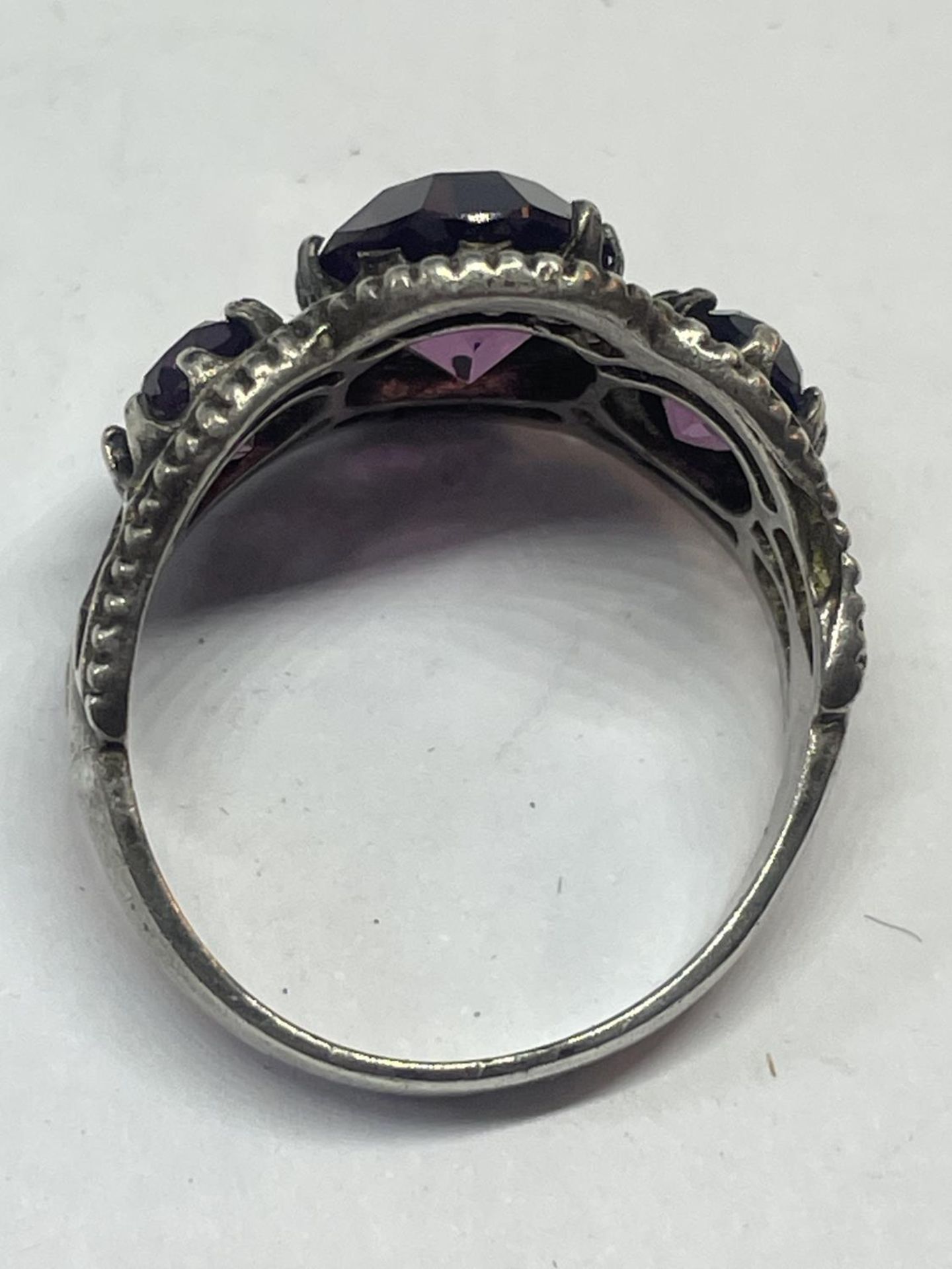 A SILVER RING WITH AMETHYST COLOURED STONES - Image 3 of 3