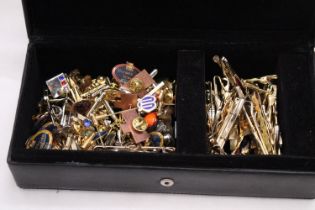 A LEATHER BOX OF TIE STUDS