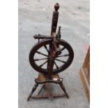 A BEECH FRAMED SPINNING WHEEL ON TURNED LEGS AND STRETCHERS