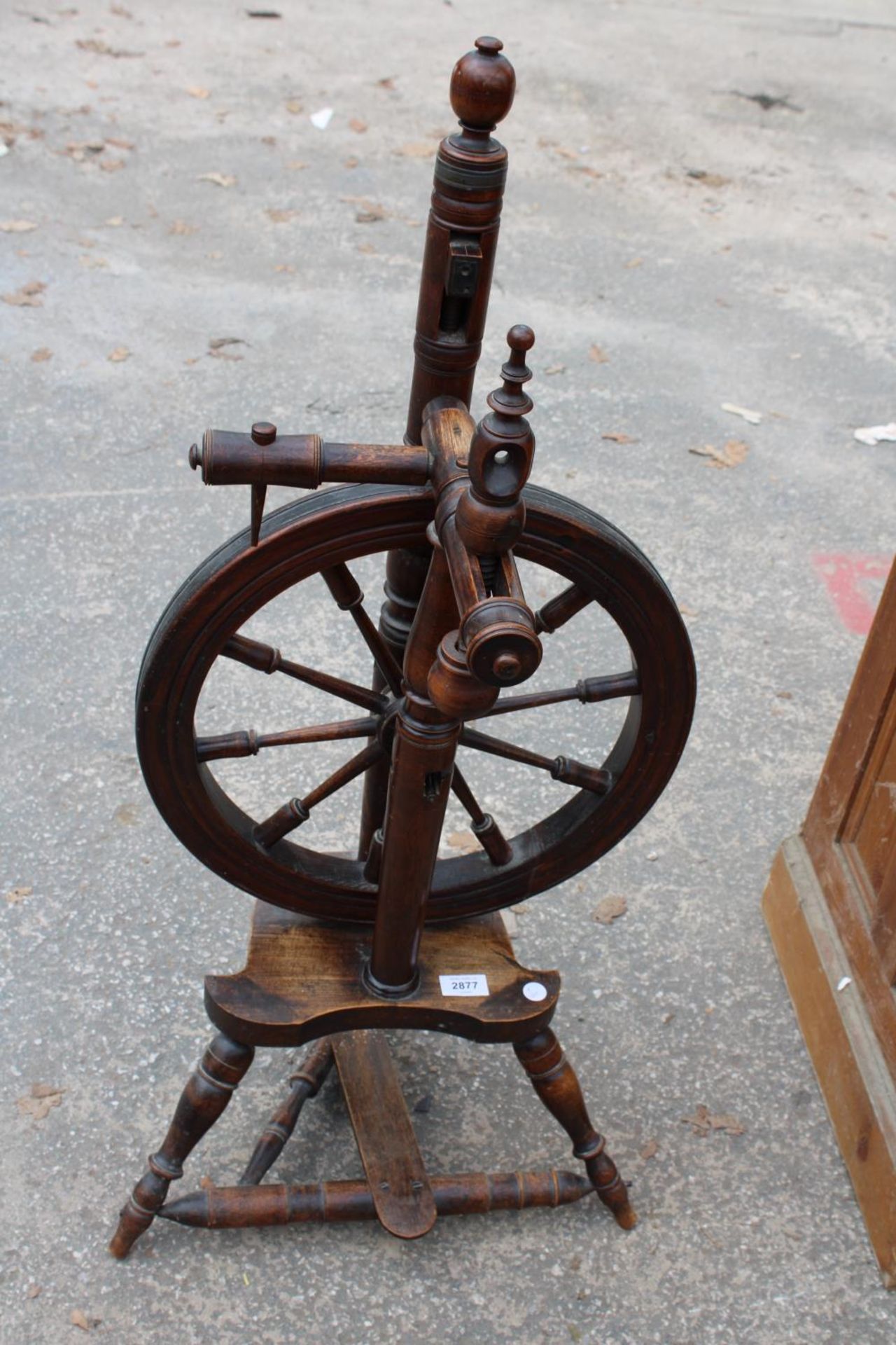 A BEECH FRAMED SPINNING WHEEL ON TURNED LEGS AND STRETCHERS