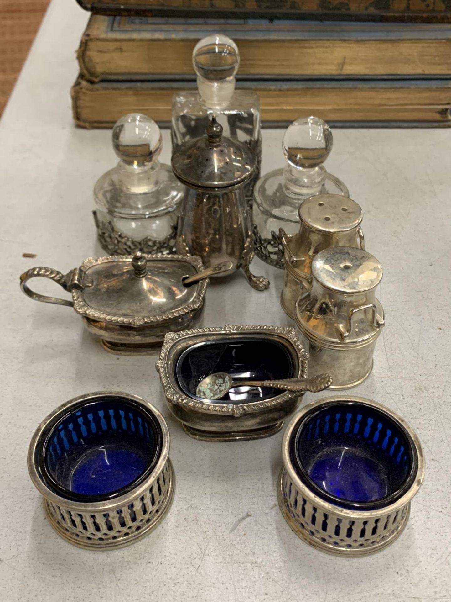 A QUANTITY OF SMALL SILVER PLATED ITEMS TO INCLUDE SALTS WITH BLUE GLASS LINERS, A MILK CHURN
