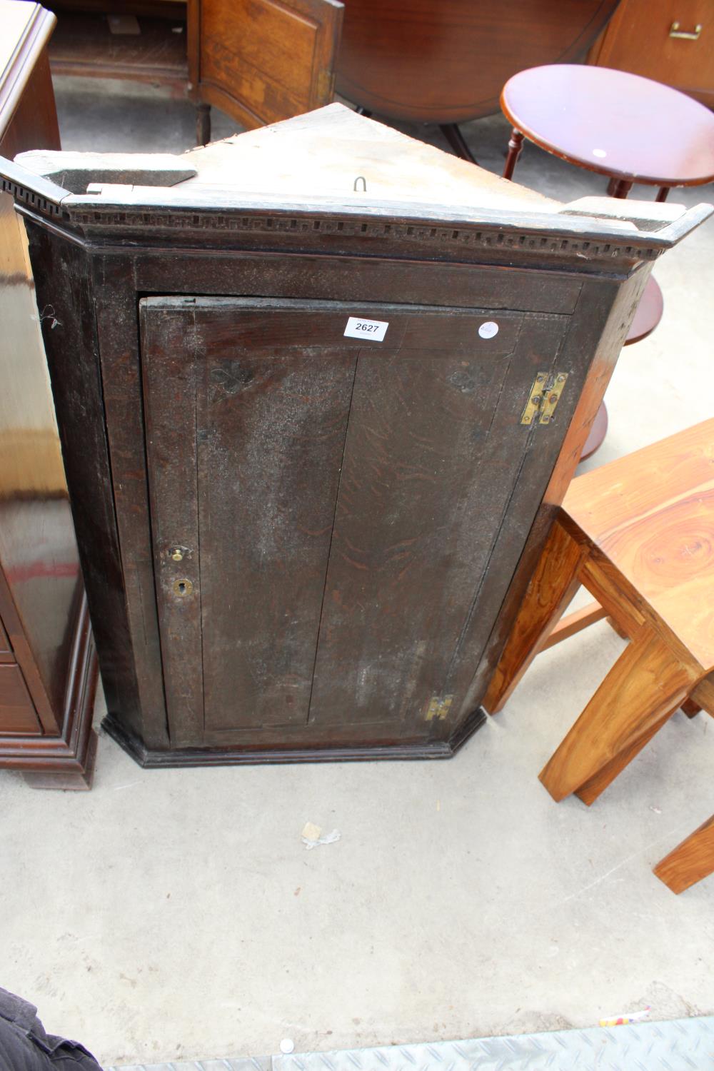 A GEORGE III OAK AND CROSSBANDED CORNER CUPBOARD WITH H BRASS HINGES AND SHAPED INTERIOR SHELVES,