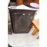 A GEORGE III OAK AND CROSSBANDED CORNER CUPBOARD WITH H BRASS HINGES AND SHAPED INTERIOR SHELVES,