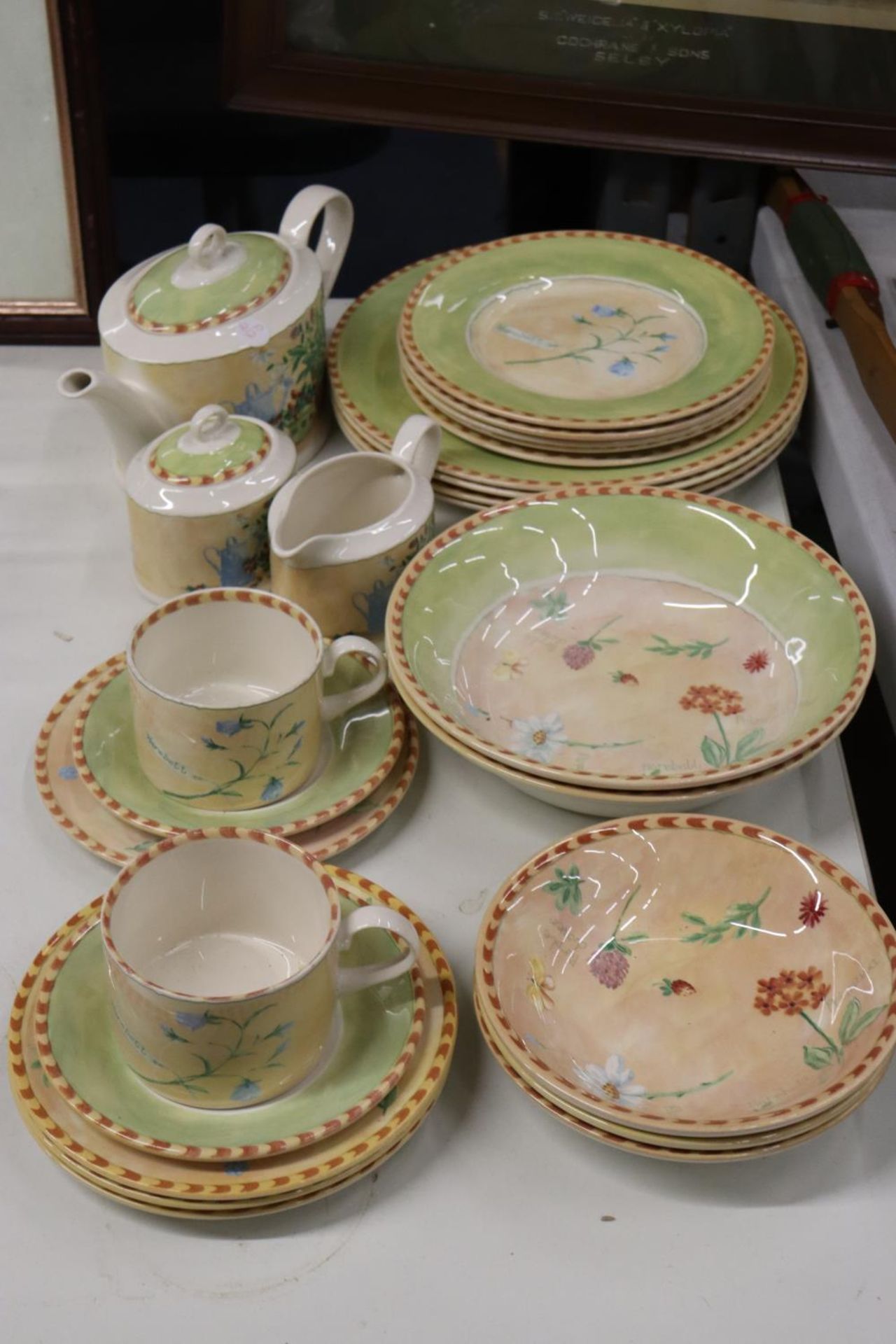 A PART DINNER SERVICE TO INCLUDE PLATES, LARGE BOWLS, DESSERT BOWLS, A TEAPOT, SUGAR BOWL, CREAM