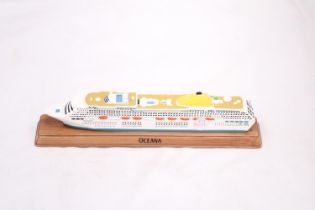 A HEAVY, SOLID, OCEAN LINER ON WOODEN STAND, 'OCEANA', LENGTH 27CM, HEIGHT 6CM