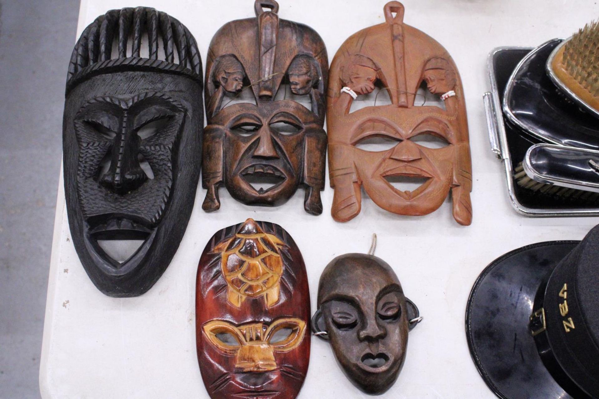 FIVE AFRICAN HAND CARVED WOODEN MASKS - PLUS TWO SPEARS