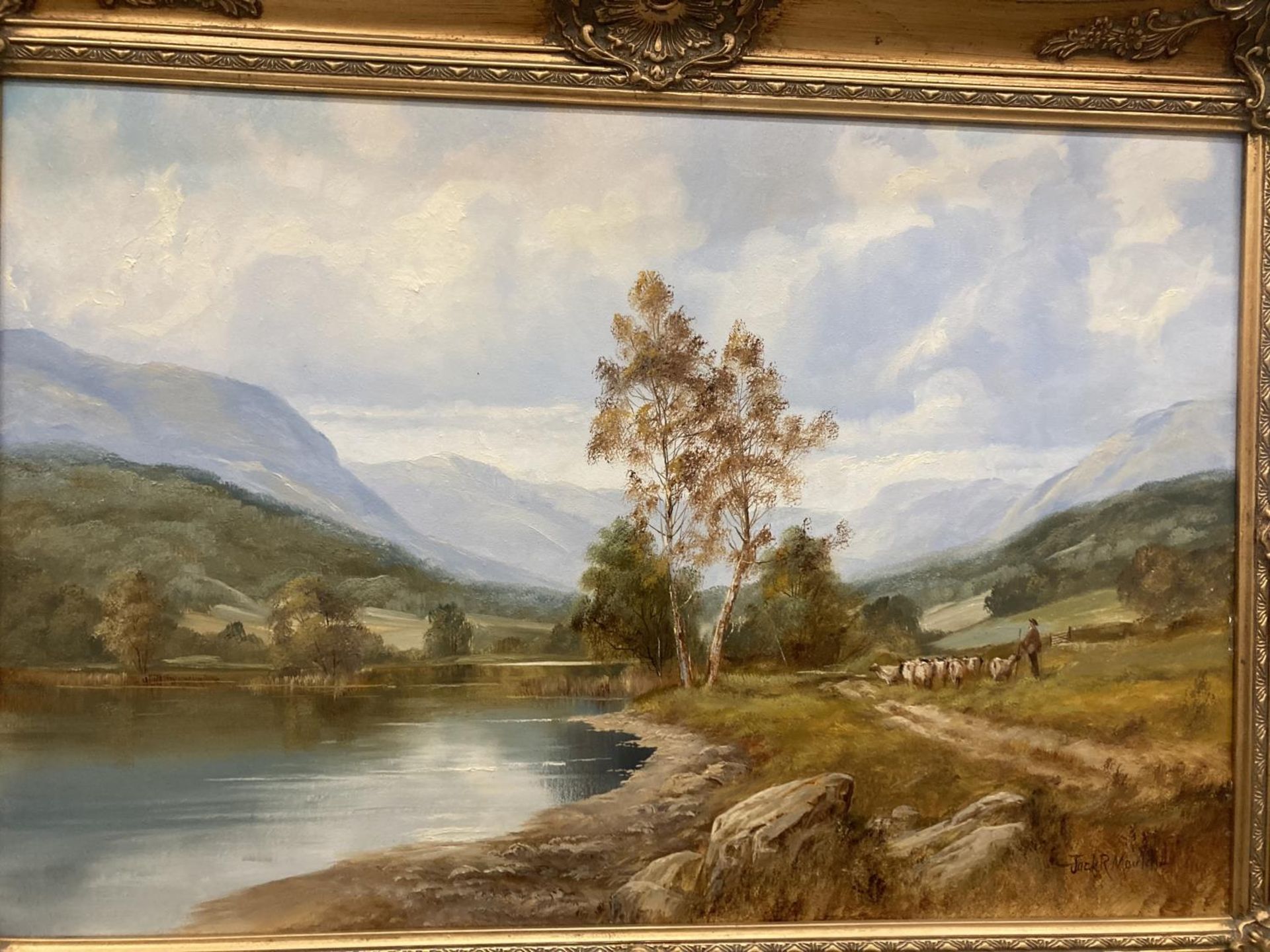 A GILT FRAMED OIL ON CANVAS OF A LAKE SCENE WITH A FARMER MOVING STOCK ...
