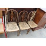 THREE WINDSOR STYLE WHEEL-BACK DINING CHAIRS WITH SPLIT CANE SEATS