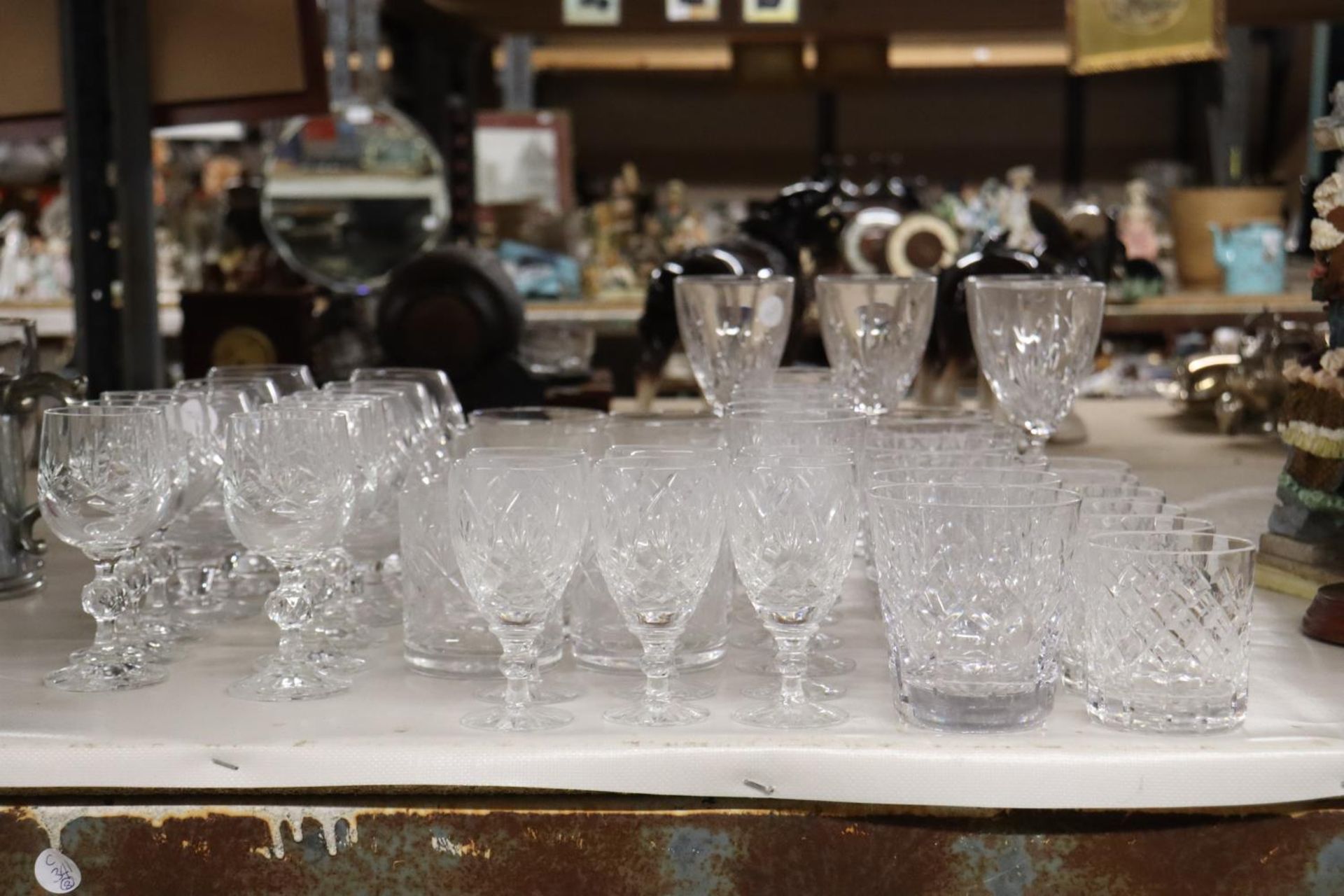 A LARGE QUANTITY OF DRINKING GLASSES TO INCLUDE BRANDY, SHERRY, WHISKEY, ETC.,