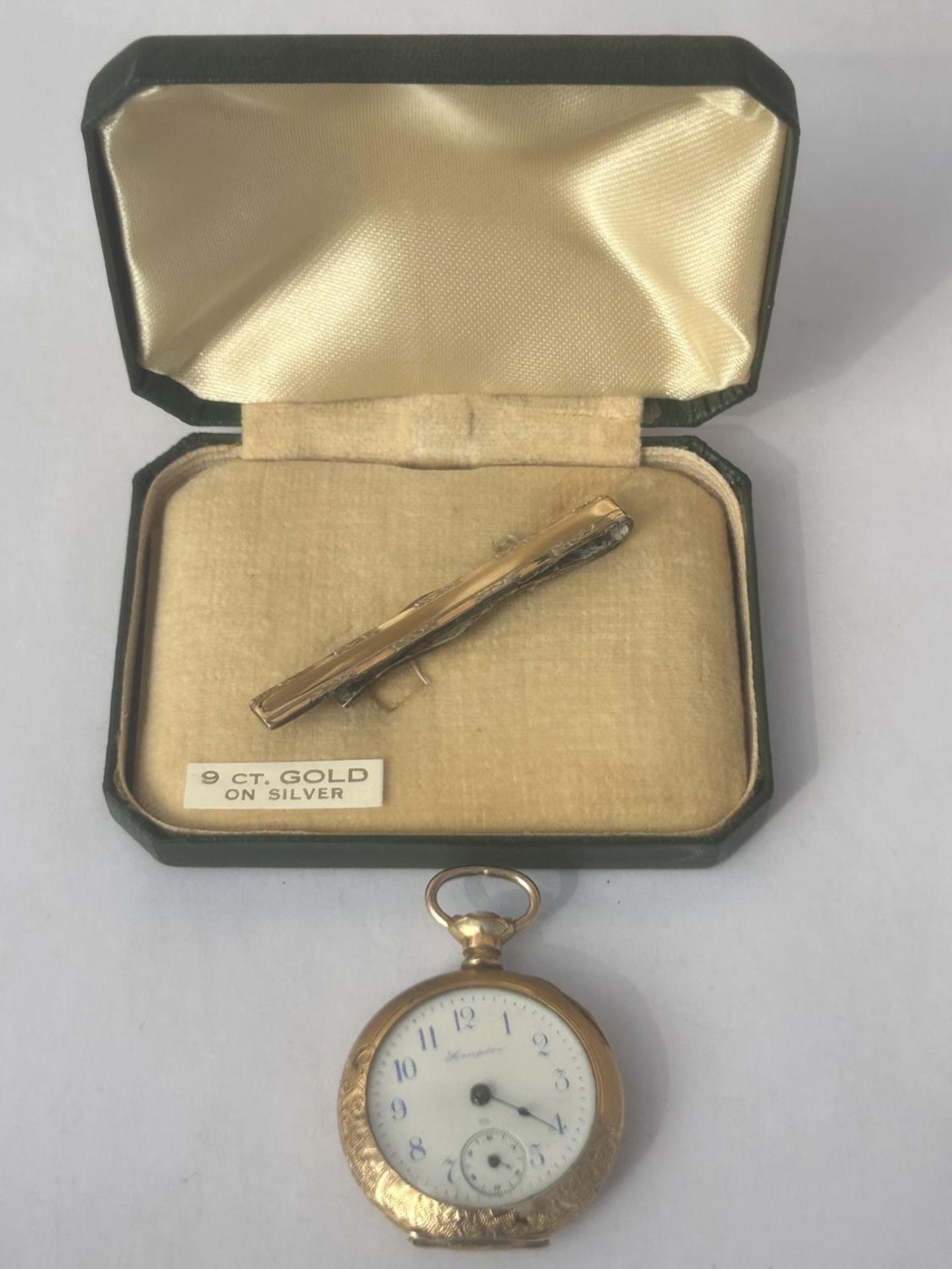 TWO GOLD PLATED ITEMS TO INCLUDE A 9CT GOLD ON SILVER TIE PIN AND A 14CT GOLD PLATED FOB WATCH