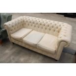 A MODERN CREAM FAUX LEATHER CHESTERFIELD THREE SEATER SETTEE