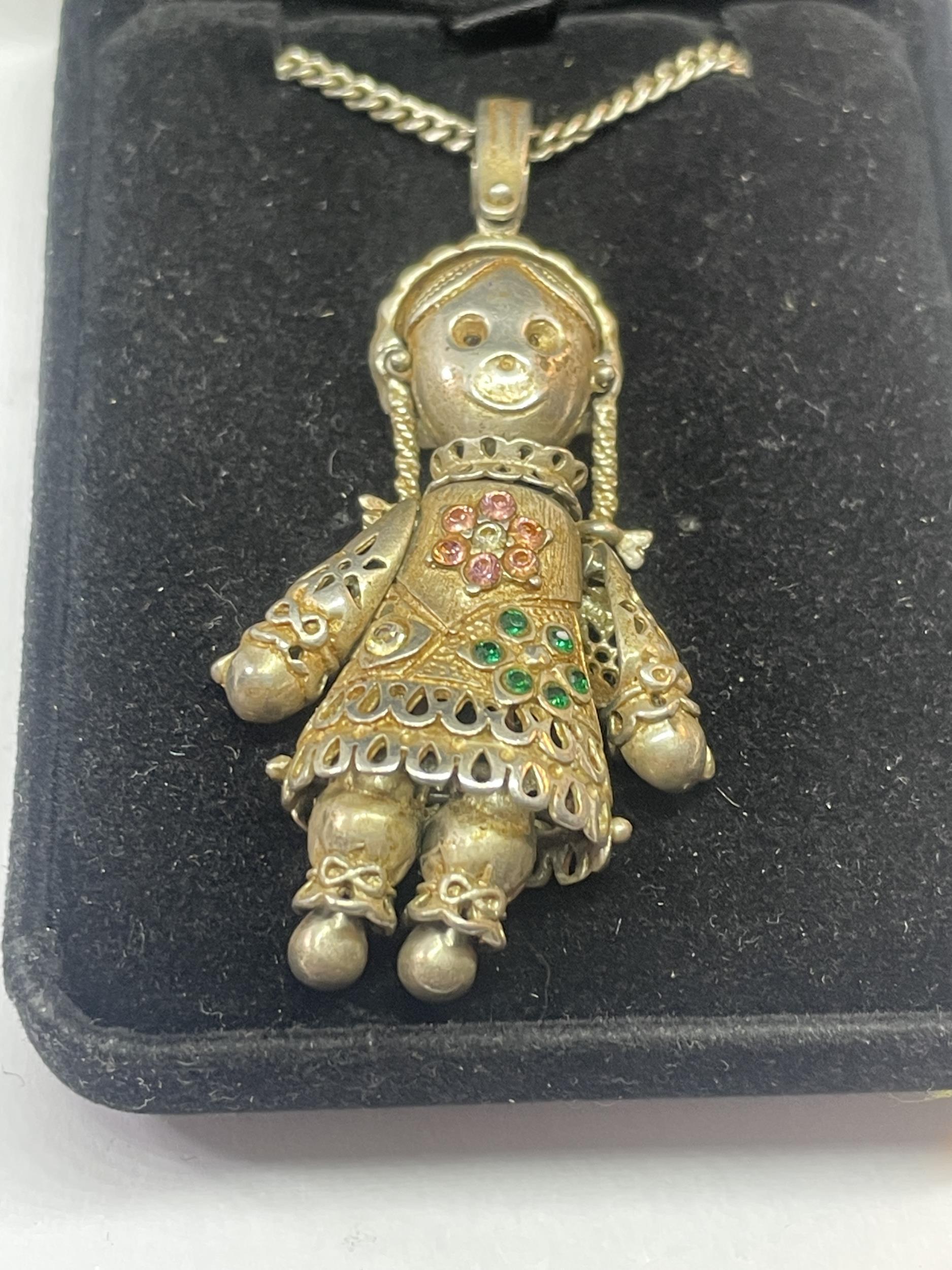 A SILVER DOLL NECKLACE IN A PRESENTATION BOX