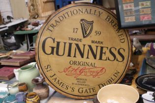 A LARGE WOODEN CIRCULAR GUINESS ADVERTISING SIGN 24" DIAMETER