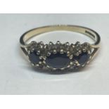 A 9 CARAT GOLD RING WITH THREE IN LINE SAPPHIRES SURROUNDED BY CUBIC ZIRCONIAS SIZE Q