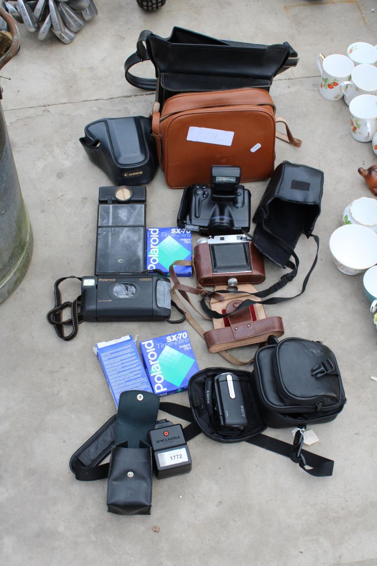 AN ASSORTMENT OF CAMERA EQUIPMENT TO INCLUDE A POLAROID CAMERA, A PENTAX FLASH AND A SONY