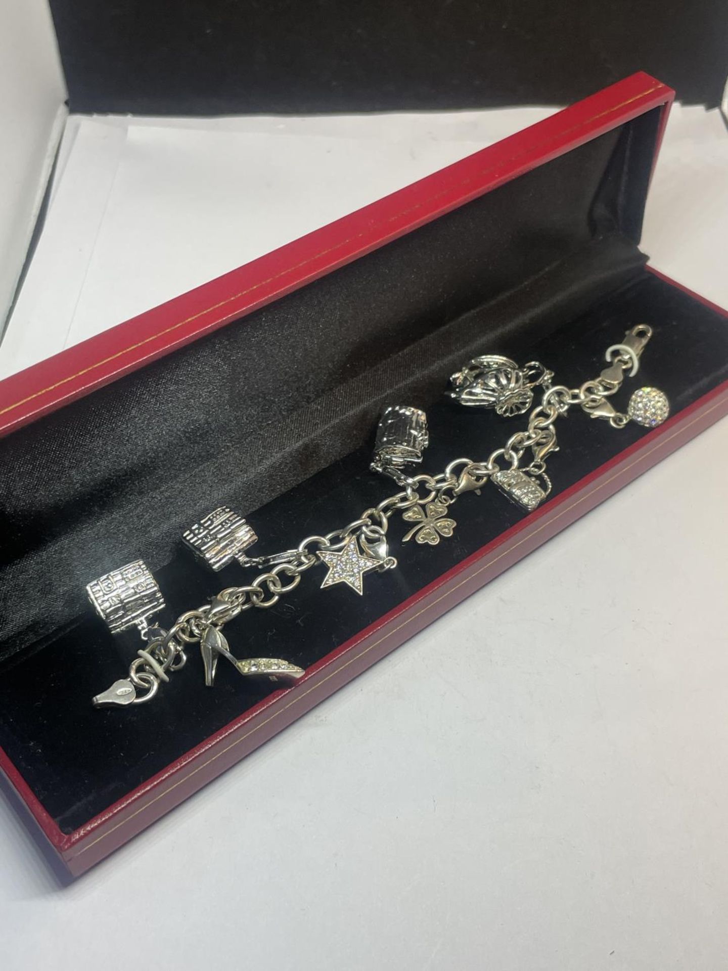 A SILVER CHARM BRACELET WITH NINE CHARMS IN A PRESENTATION BOX