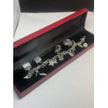 A SILVER CHARM BRACELET WITH NINE CHARMS IN A PRESENTATION BOX