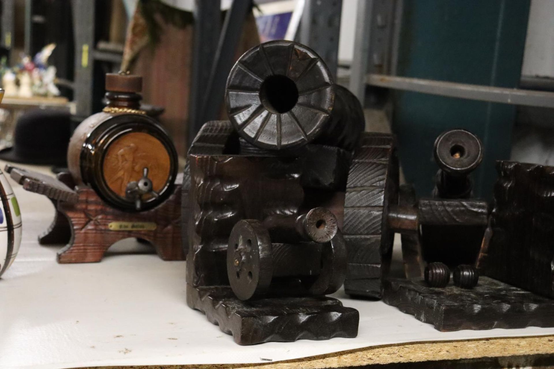 TWO WOODEN HANDCARVED CANNONS TOGETHER WITH WOODEN BOOK ENDS AND A VINTAGE SHERRY DECANTER