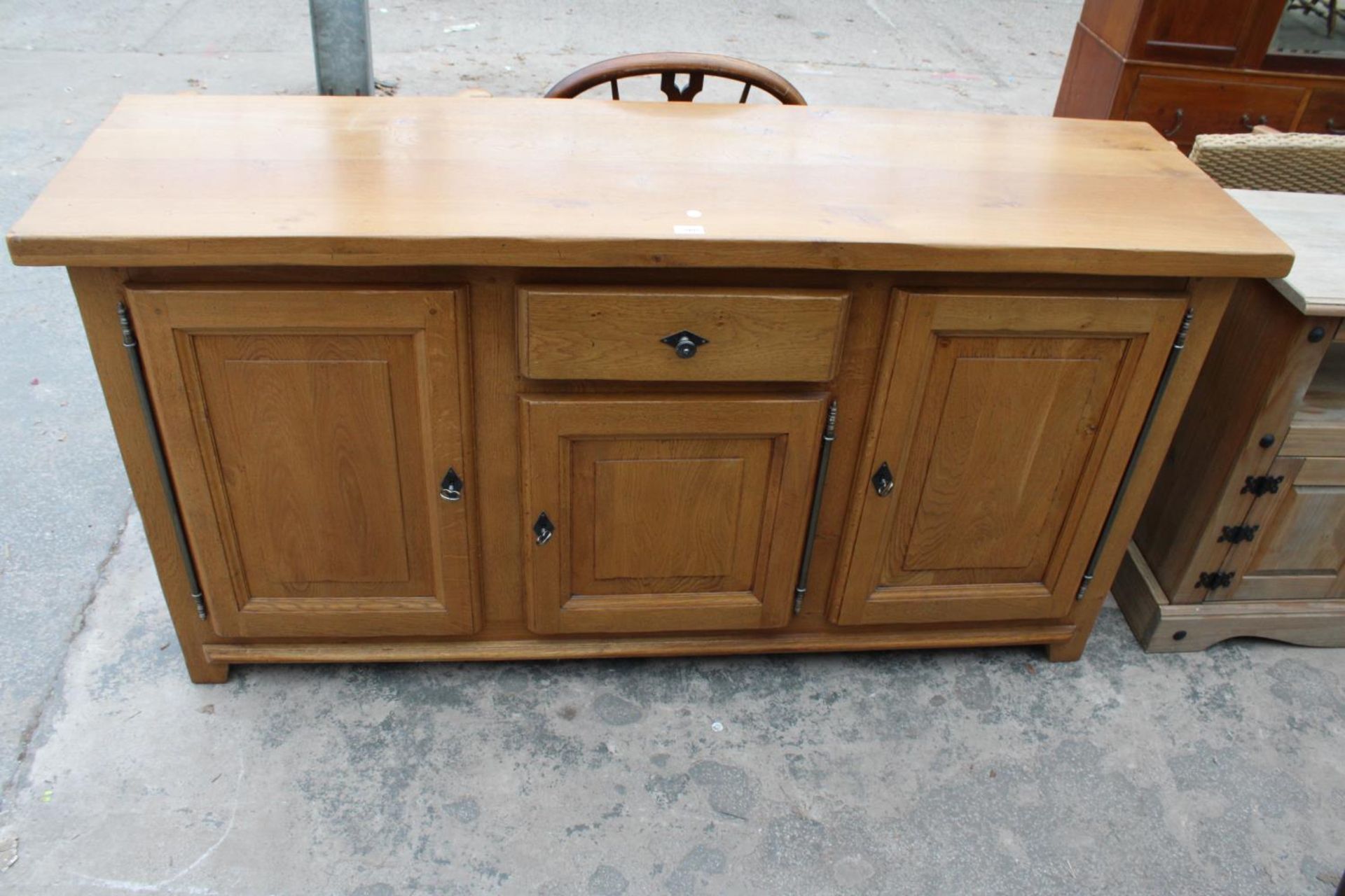 A MODERN OAK SIDEBOARD ENCLOSING THREE PANELLED DOORS AND SINGLE DRAWER, 68"