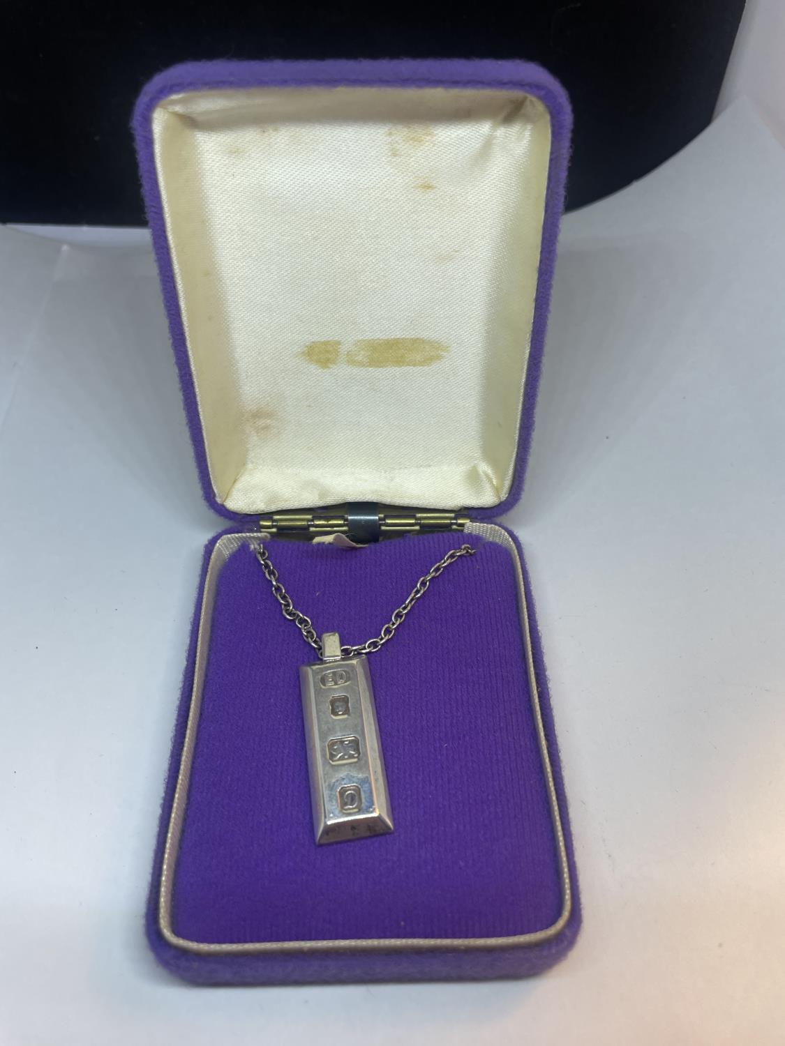 A SILVER INGOT AND CHAIN IN A PRESENTATION BOX