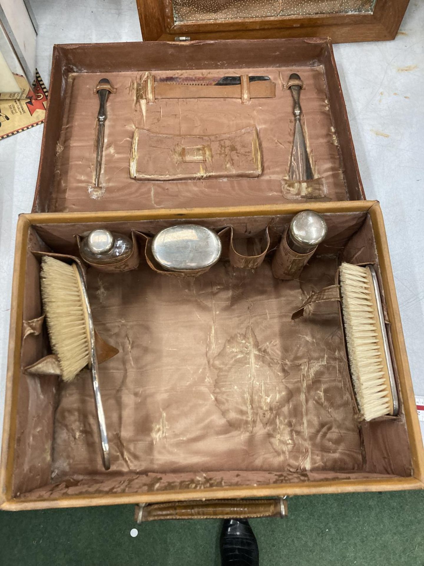 A VINTAGE LEATHER TRAVEL CASE WITH HALLMARKED BIRMINGHAM SILVER CONTENTS TO INCLUDE BRUSHES,