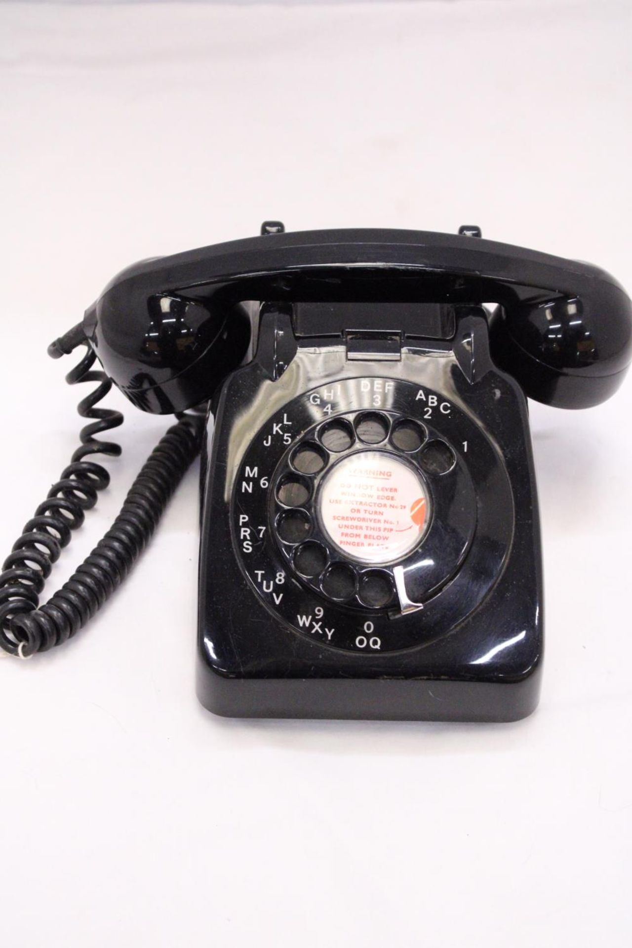 A VINTAGE BLACK TELEPHONE WITH DIAL