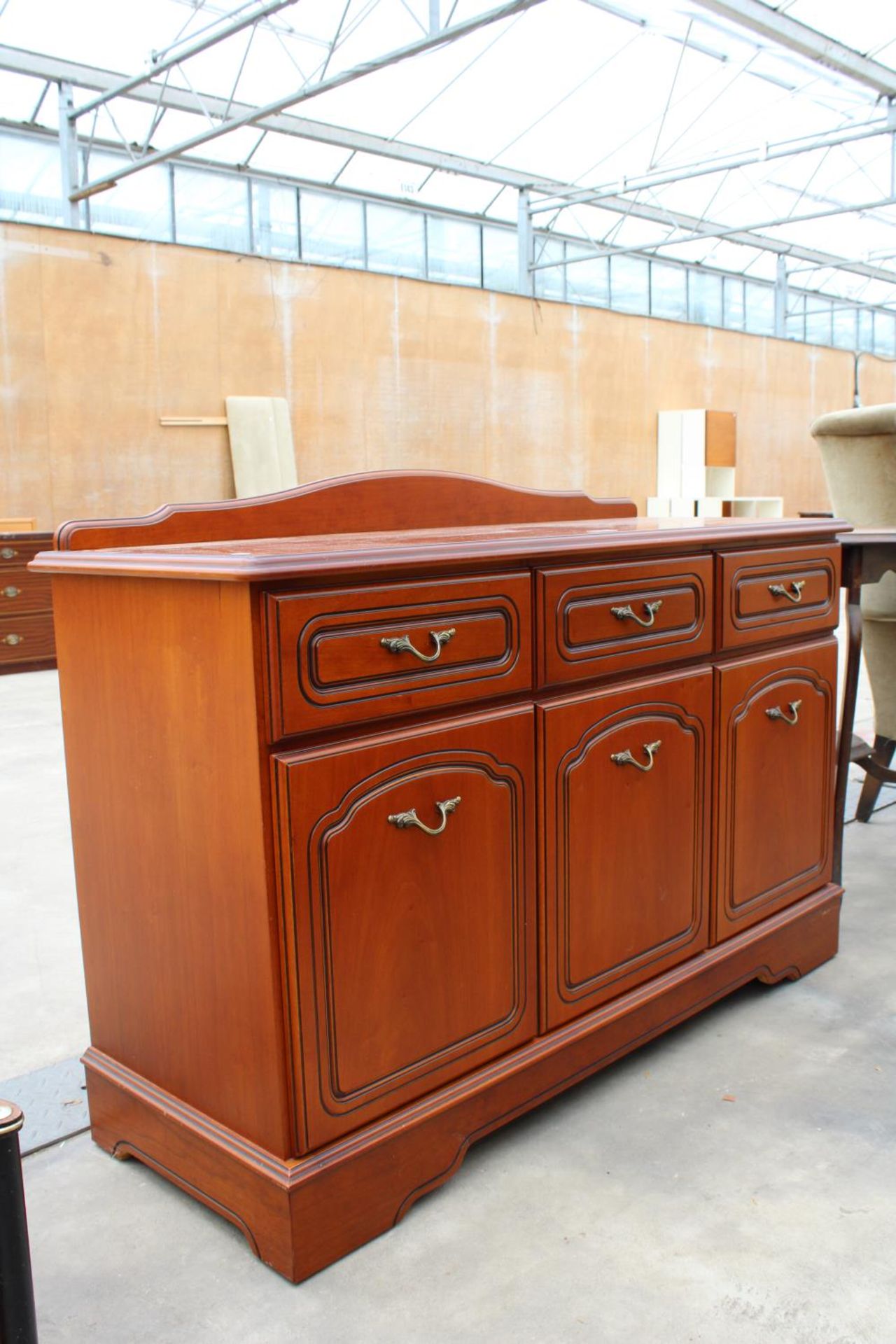 A MODERN CHERRY WOOD EFFECT SIDEBOARD ENCLOSING THREE DRAWERS AND THREE CUPBOARDS WITH RAISED - Image 2 of 3