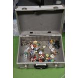A METAL STORAGE CASE CONTAINING A SELECTION OF VINTAGE KEYRINGS AND FIGURES