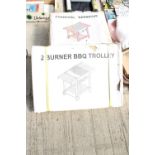 A NEW AND BOXED CHARCOAL BBQ AND A NEW AND BOXED TWO BURNER BBQ TROLLEY (BOXES WATER DAMAGED)