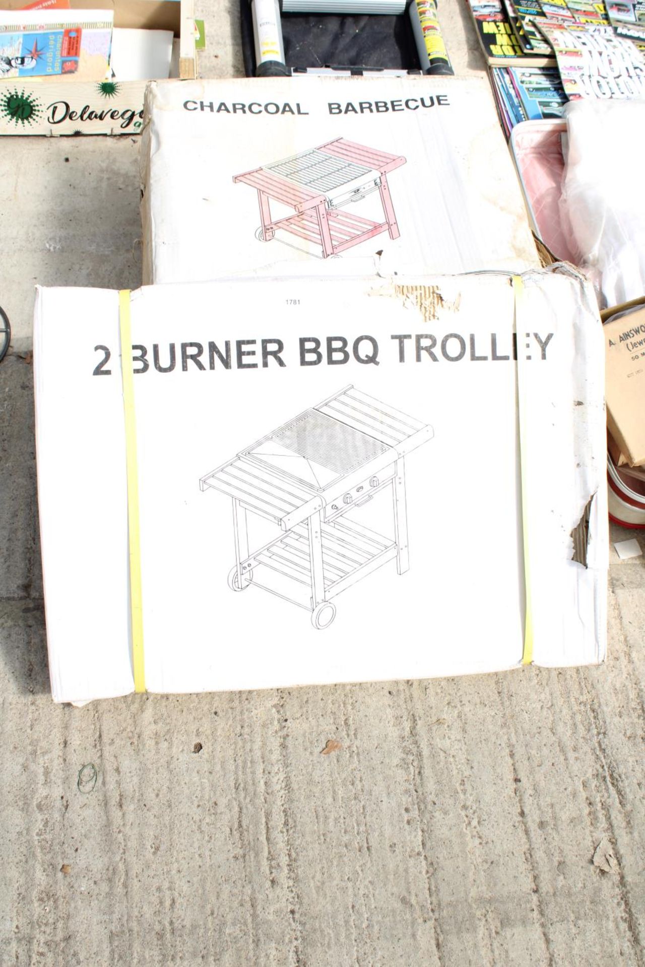 A NEW AND BOXED CHARCOAL BBQ AND A NEW AND BOXED TWO BURNER BBQ TROLLEY (BOXES WATER DAMAGED)