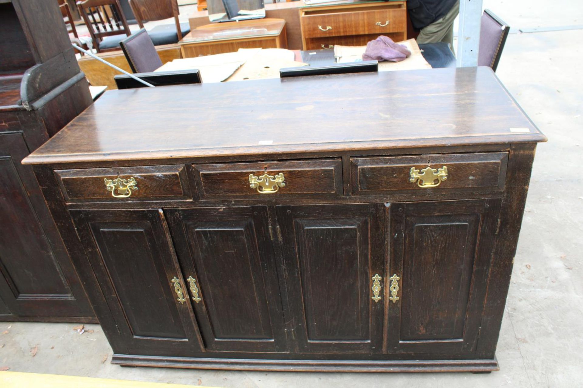 AN OAK GEORGE III STYLE DRESSER WITH FOUR CUPBOARDS AND THREE DRAWERS AND BRASS HANDLES, 60" WIDE